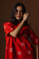 Close-up front view of model Briana showcasing the soft neckline and block printed floral print on the red linen blouse.