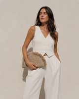 Village Thrive Seagrass Half Moon Clutch handcrafted from natural seagrass with a frayed edge design.