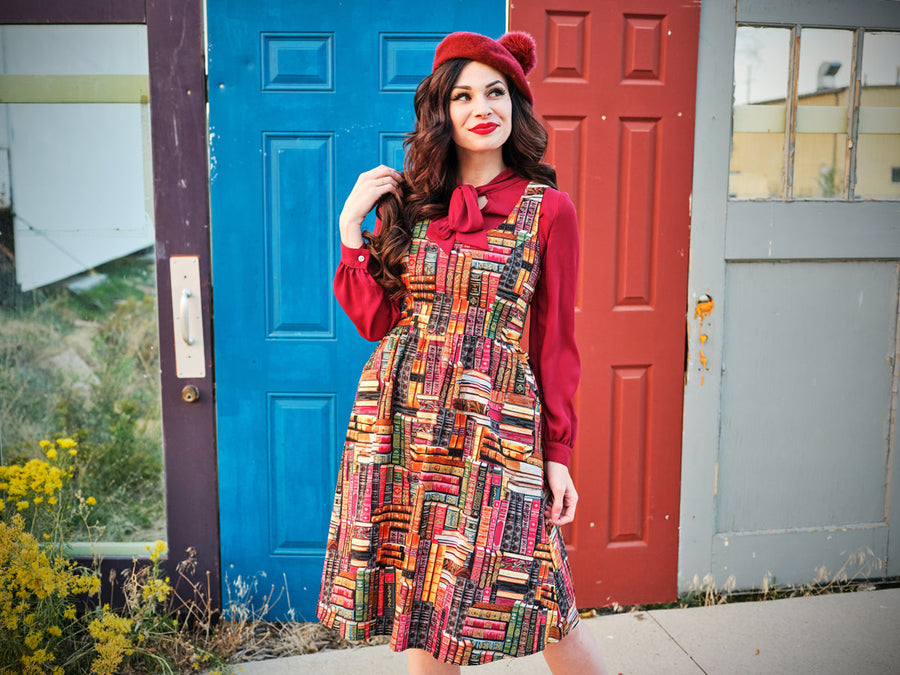 Full-length view of the 100% cotton Retrolicious book print fit & flare dress styled with a red beret and long-sleeve blouse.
