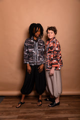 Group studio portrait featuring two models demonstrating both Mushroom grey and Sherbet orange colorways of the Megan-Ilene Studio Jacket side-by-side.  