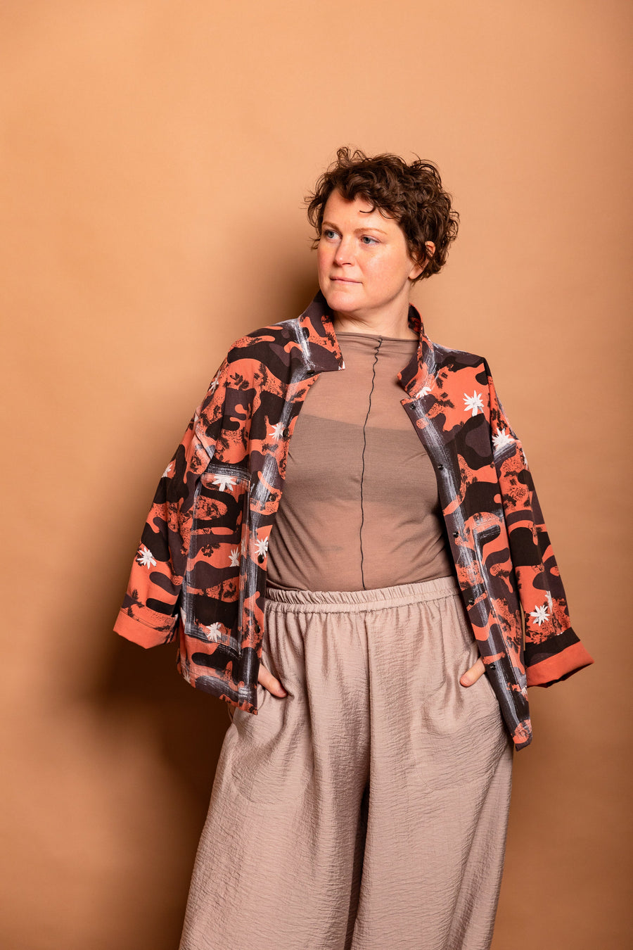 Studio portrait showing the open front styling of the Sherbet orange Japanese twill Studio Jacket over a neutral base.