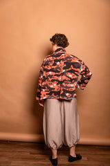 Full back view showcasing the straight-cut cropped hem and dropped shoulder construction on the Sherbet orange jacket.