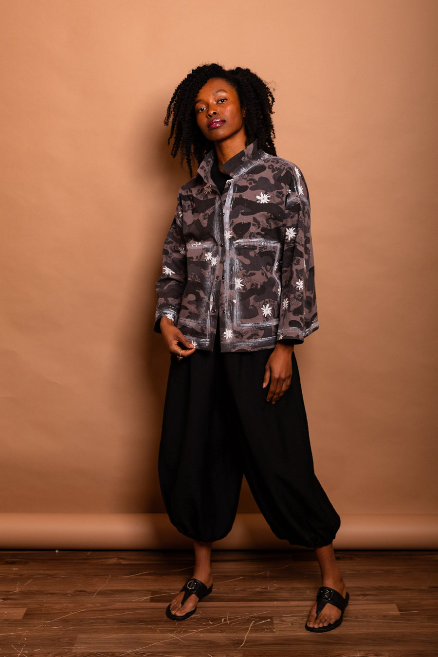 Full-length view of a model wearing the Mushroom grey/black camouflage Studio Jacket with hands in pockets.