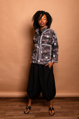 Standing front portrait showcasing the popped collar, brass snaps, and boxy silhouette of the Mushroom grey Studio Jacket.