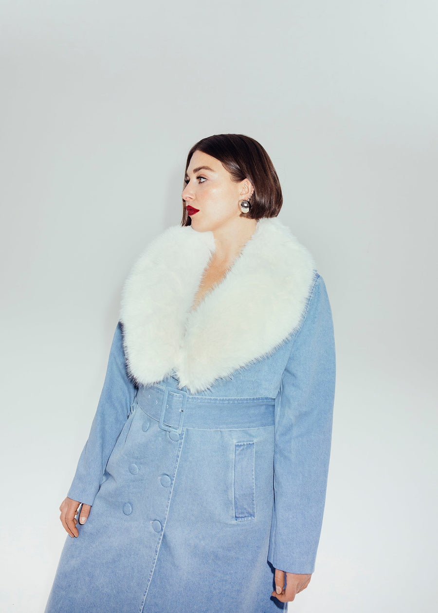 Close-up profile view of a model wearing the Hilary MacMillan Tamika trench coat with its plush, removable creamy white faux fur collar and matching denim belt.