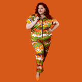 Full-length front view of a model posing with a hand on her waist wearing the Blue Platypus Earth-toned Meadow Print cotton stretch jumpsuit.