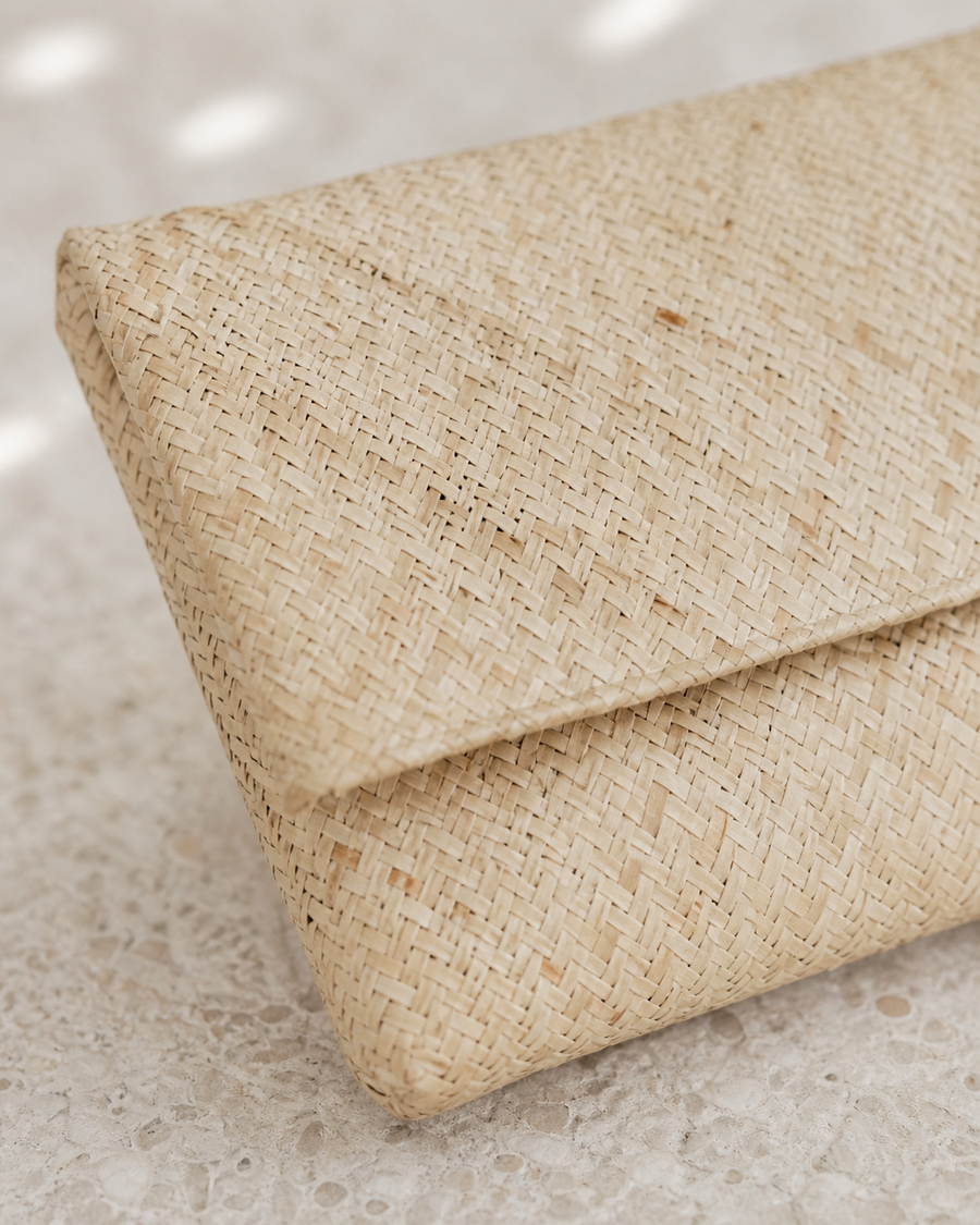 Close-up macro shot showcasing the intricate, tight geometric weave pattern of the natural straw clutch material.