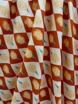 High-resolution detail shot of the 100% cotton fabric featuring a rust orange checkered pattern with cotton candy graphics.