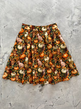 Flat lay product photograph of the Retrolicious Cats & Pumpkins A-line Skirt on a marble background.