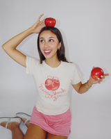 Model wearing Fruit Face Big Apple baby tee with New York City graphic