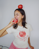 Model wearing Fruit Face Big Apple baby tee with New York City graphic