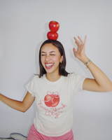 Model wearing Fruit Face Big Apple baby tee with New York City graphic