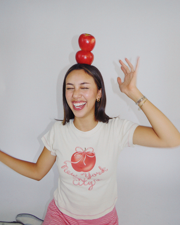 Model wearing Fruit Face Big Apple baby tee with New York City graphic