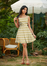 Model posing outdoors wearing the Retrolicious Pineapple Skater Dress featuring an all-over watercolor pineapple print and flirty A-line skirt.