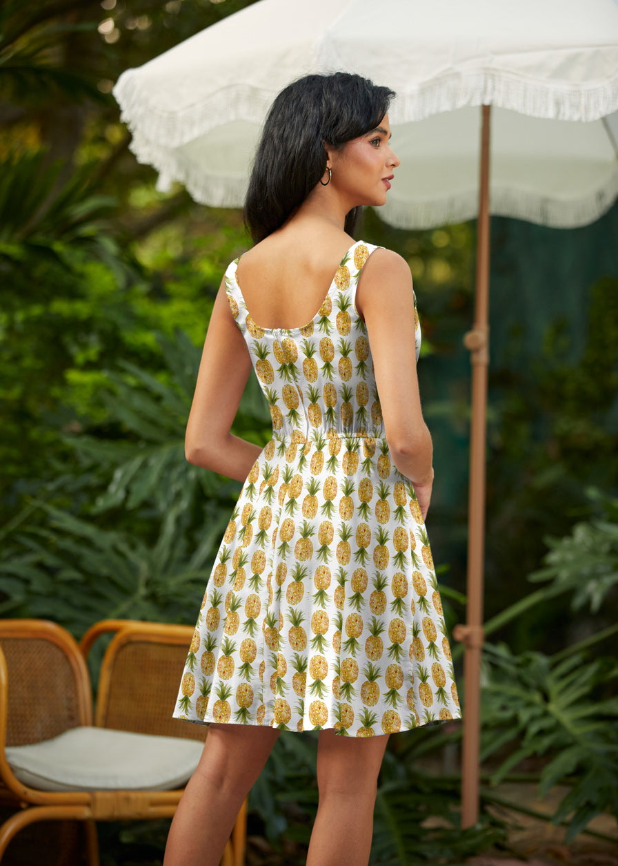 Back view of a model wearing the Retrolicious Pineapple Skater Dress highlighting the scoop back silhouette and elastic waist.