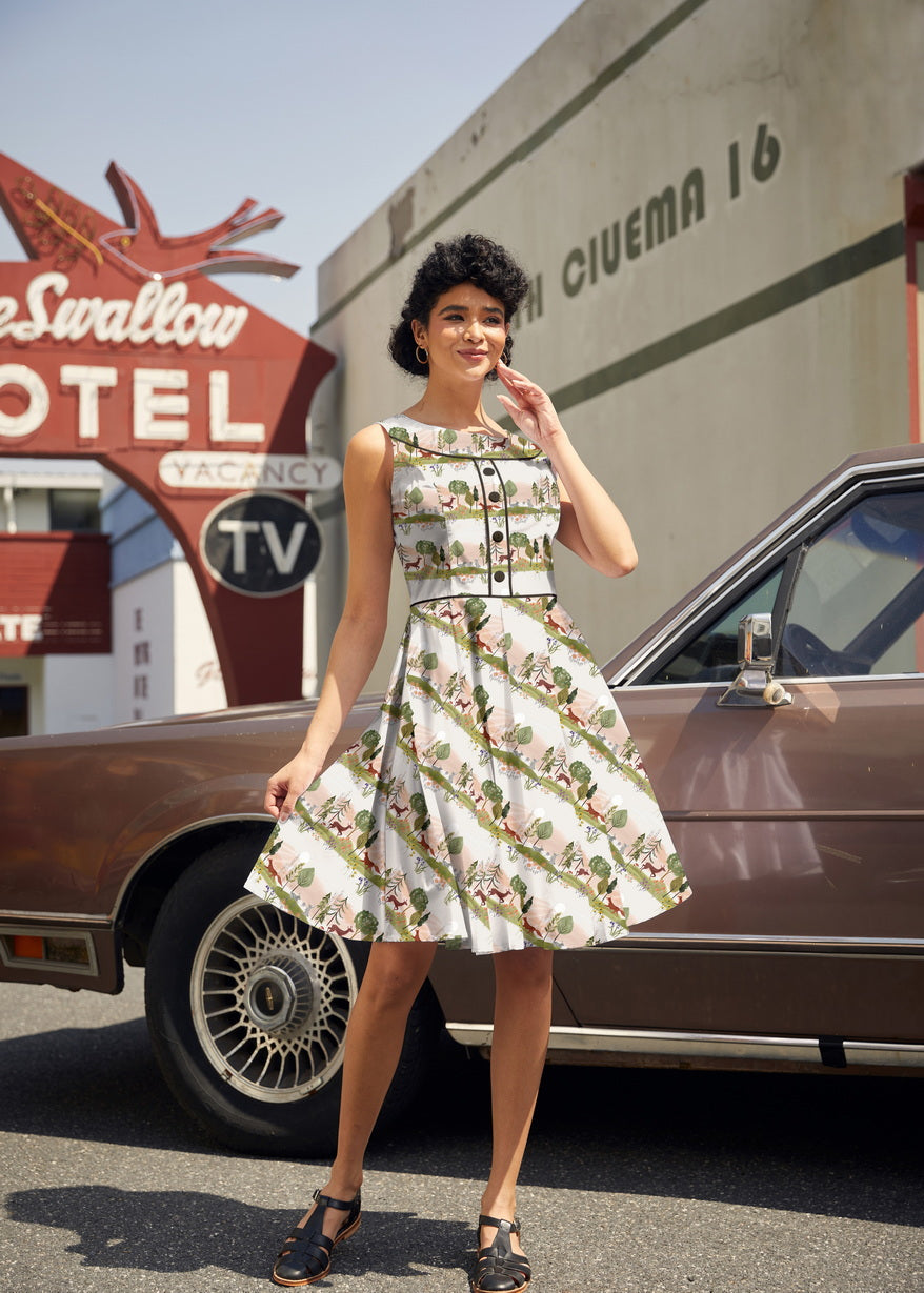 Full-length shot of a model wearing the Retrolicious Woodland Sunset Elizabeth Dress with a pleated knee-length skirt and black piping details.