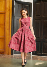 Full-length photo of a model holding out the full A-line swing skirt of the Red Diamond print 1950s midi dress.