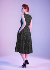 Three-quarter back perspective of the model showing the back profile, hidden side pocket placement, and midi swing length.