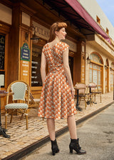 Back perspective view of a model in the Retrolicious Greta dress showing the back V-neckline and full gathered skirt.