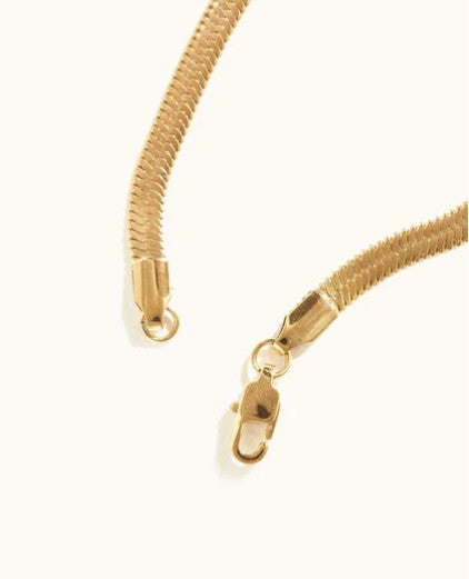 Able Close-up detail view of the lobster clasp closure and smooth woven texture of the ABLE gold herringbone necklace