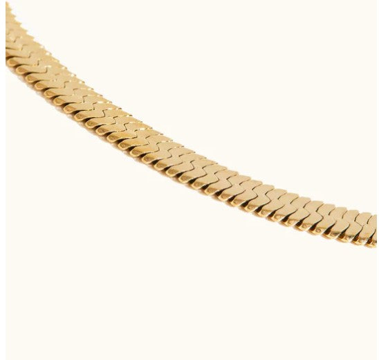 Able Close-up detail showing the flat, flexible weave of the ABLE gold herringbone chain necklace against a light background
