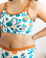 Close-up torso shot focusing on the Elana Gabrielle artichoke and bee botanical print and rust-colored flat bottom band.