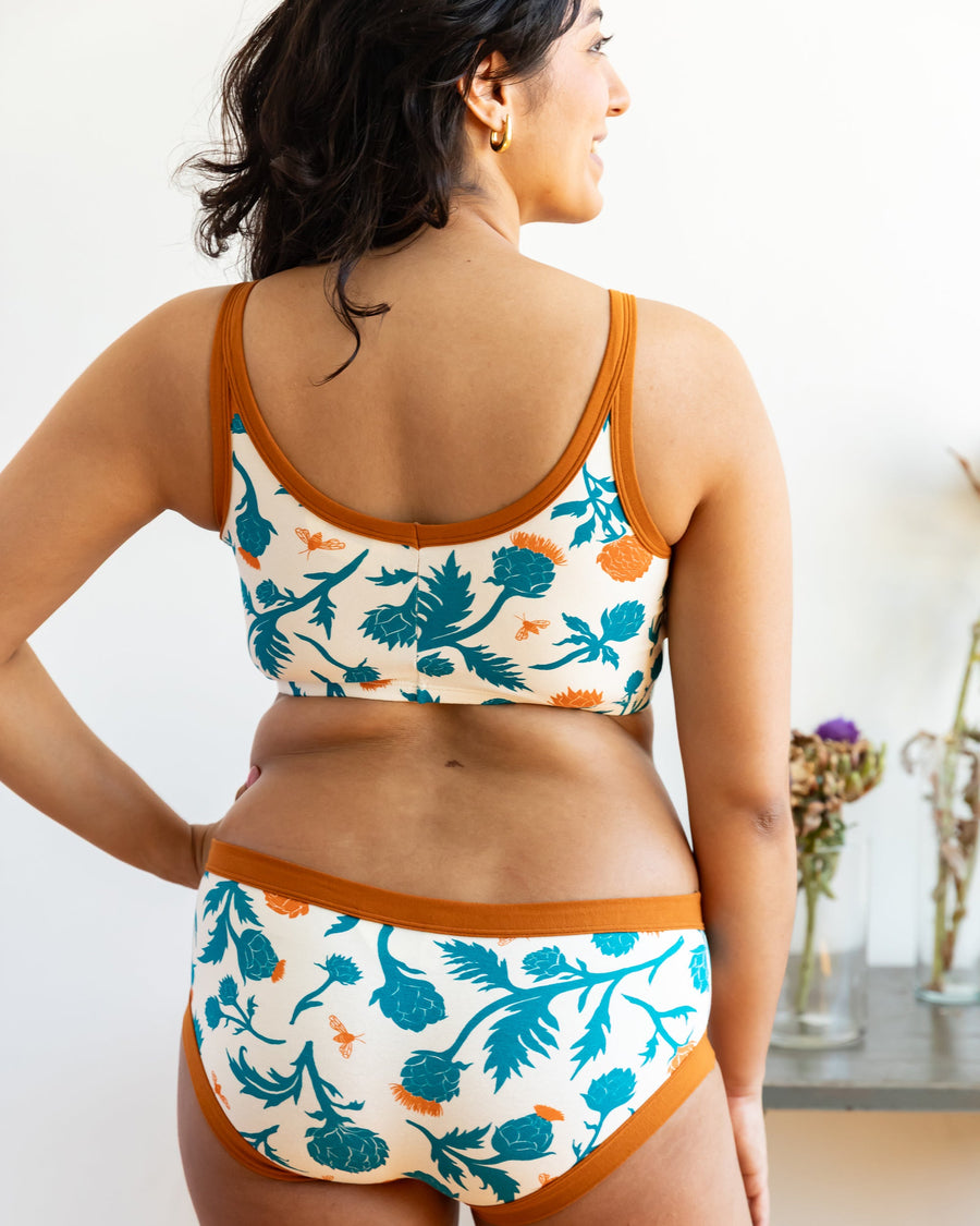 Direct back view of a model showcasing the double-layer scoop back construction and rust binding of the longline bra.