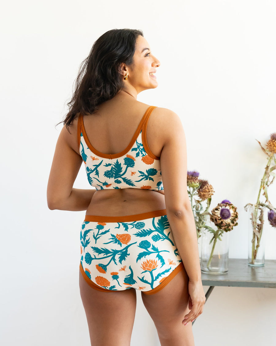 Direct back view of a model showcasing the double-layer scoop back construction and rust binding of the longline bra.