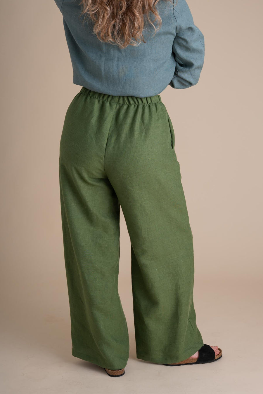 Rear view showing the high elastic waistband and full-coverage wide leg of the clover green linen Joystripe Pants.
