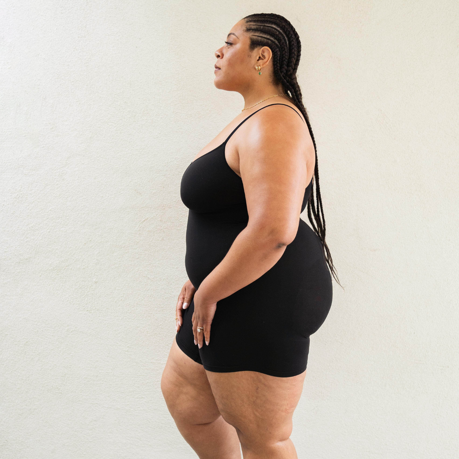 Size inclusive model in PROCLAIM Mid-Thigh Shapewear Bodysuit - bodysuit, side view