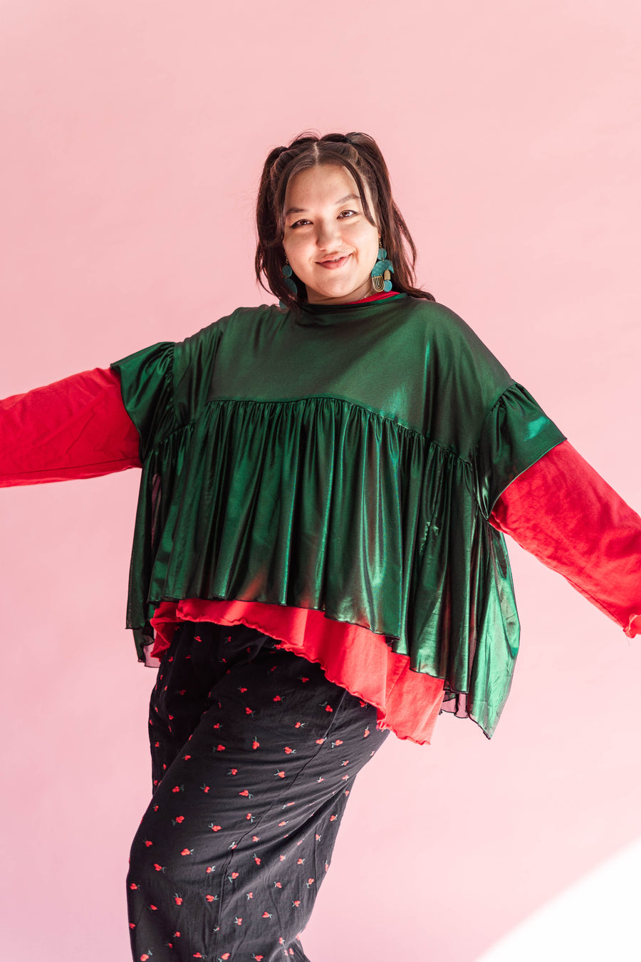 Front view of a model posing with arms extended wearing the metallic green tinsel top.