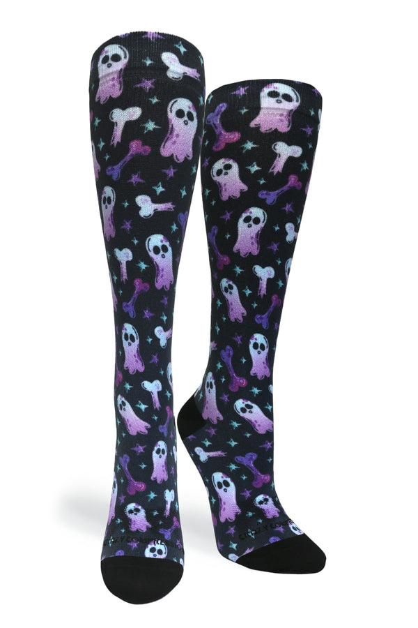 Studio shot of a pair of Crazy Compression Haunting Bones knee-high socks showing purple and blue ghost and bone graphics on black fabric.
