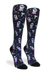 Studio shot of a pair of Crazy Compression Haunting Bones knee-high socks showing purple and blue ghost and bone graphics on black fabric.