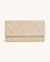 A straight-on studio shot of the Village Thrive woven clutch in the natural straw color variant, highlighting the clean envelope silhouette.