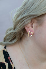 Chouette Designs a close up of a blonde wavy haired woman's ear wearing the yellow gold twist earring