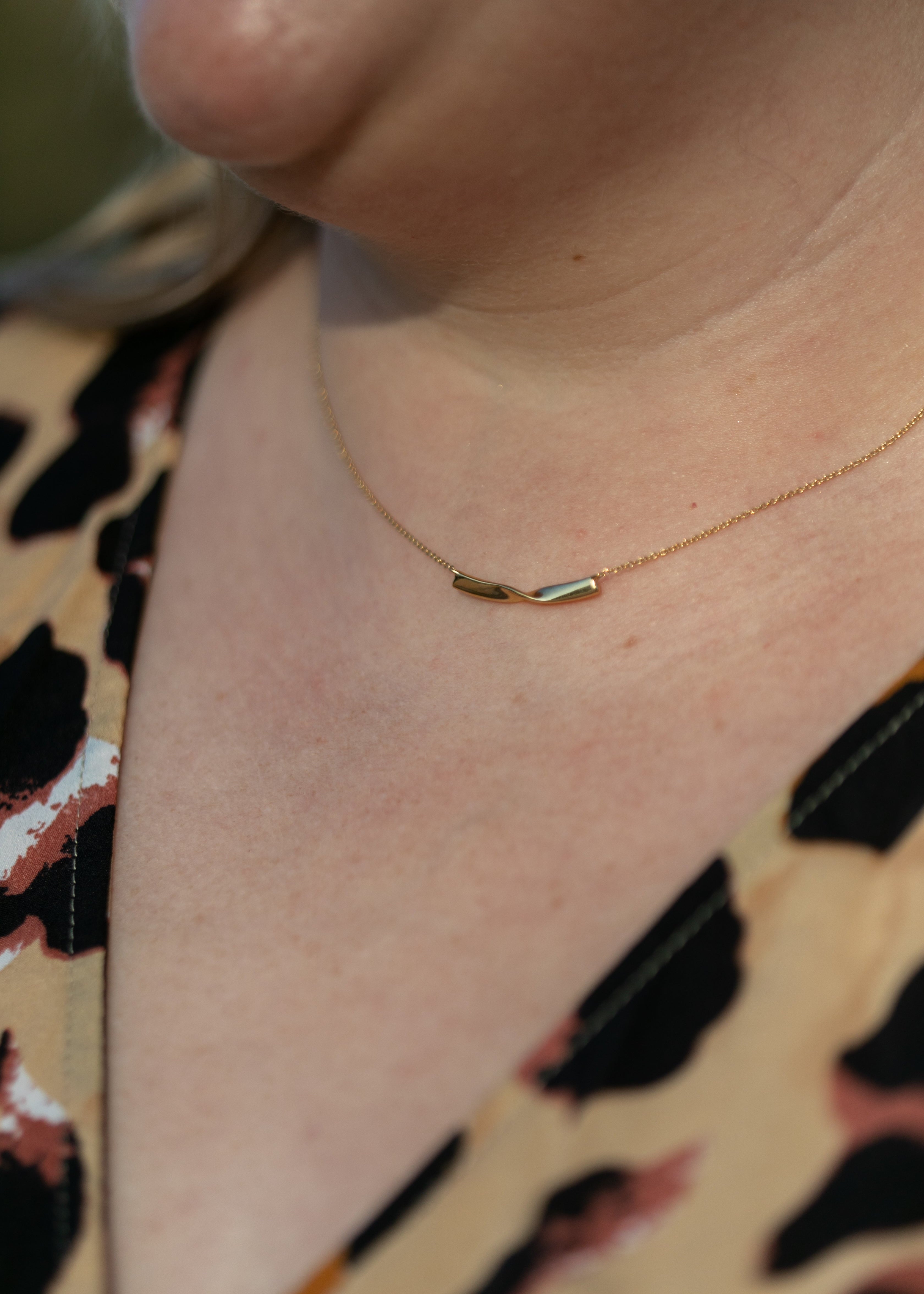 a close up of a plus size woman's neck wearing a gold twist necklace #color_gold