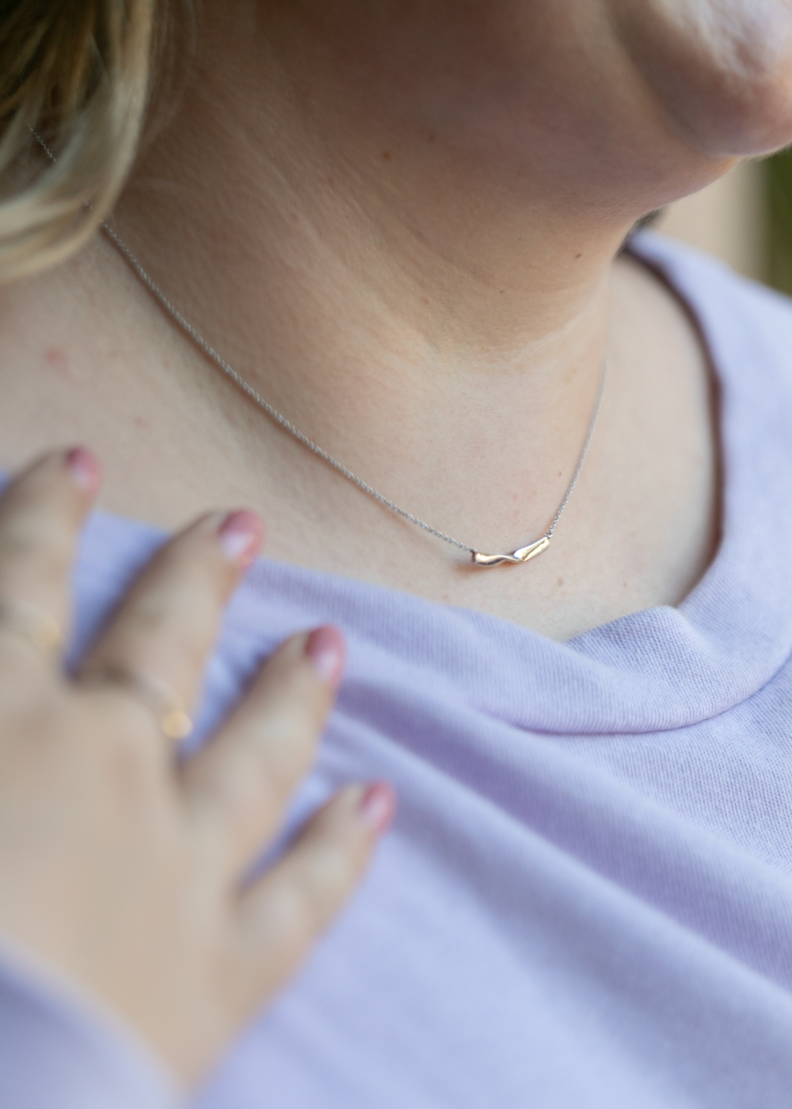 a close up of a plus size woman's neck wearing a silver twist necklace. #color_silver