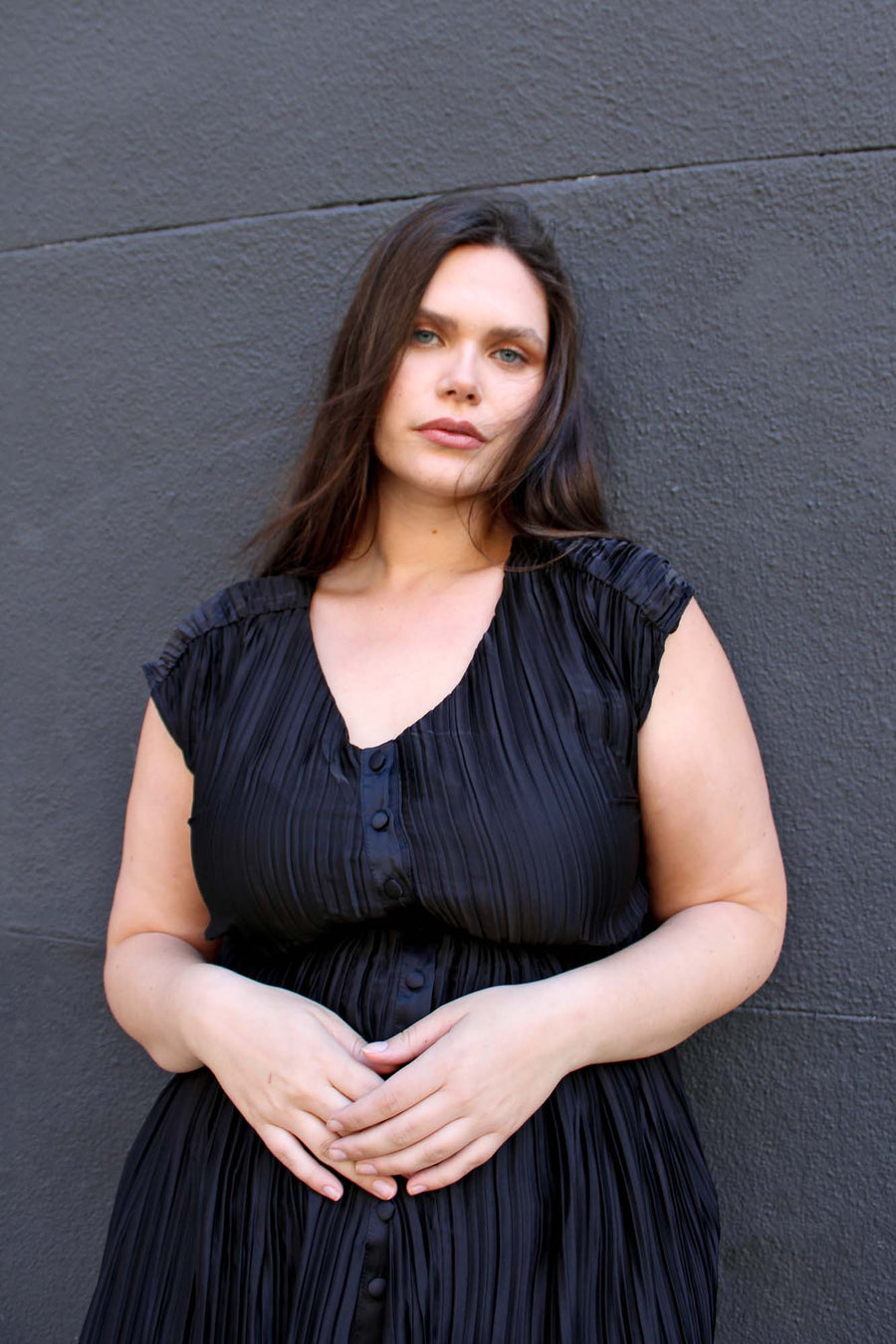 Tamara Malas Penelope Dress Black pleated button down front close up view on size inclusive model