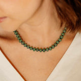 Close-up shot of a model wearing the Sela Designs Green Aventurine Margot Beaded Necklace with navy Miyuki glass accents.