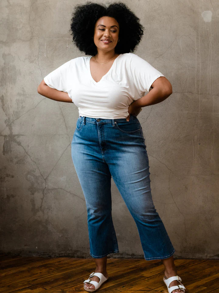 Front view of ABLE Holly high-rise kick flare stretch denim jeans in medium indigo wash, featuring a fitted silhouette and ankle-length flared hem. Plus Size
