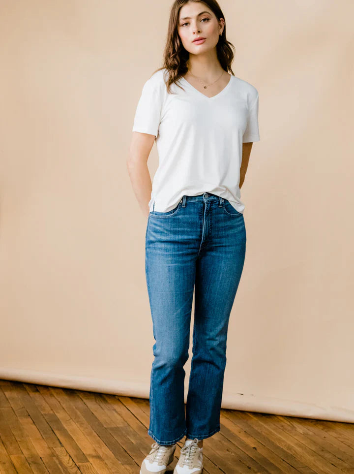 Front view of ABLE Holly high-rise kick flare stretch denim jeans in medium indigo wash, featuring a fitted silhouette and ankle-length flared hem.