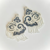 Flat lay view of the CLOUD hand-embroidered beaded cloud earrings showing velvet backing and glass beadwork.