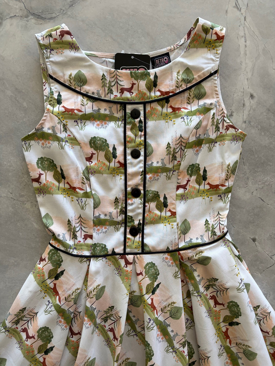 Flat lay detail of the Retrolicious Woodland Sunset dress bodice featuring front black non-functional buttons, black contrast piping, and brand tag.