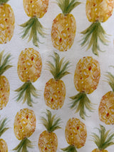 Close-up fabric print detail of the Retrolicious Pineapple Skater Dress showing yellow and green watercolor pineapples on white cotton.