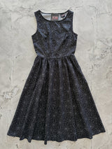 Full-length flat lay photograph of the Retrolicious Spiderweb Midi Dress on a grey marble background.