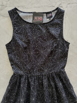 Close-up flat lay shot of the high neckline, fitted bodice, and Retrolicious brand label on the Spiderweb Midi Dress.
