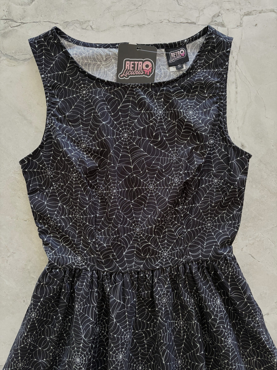 Close-up flat lay shot of the high neckline, fitted bodice, and Retrolicious brand label on the Spiderweb Midi Dress.