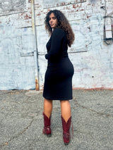Rear perspective view of Sarah wearing the black NOOWORKS Demi Dress showing its sleek back silhouette.