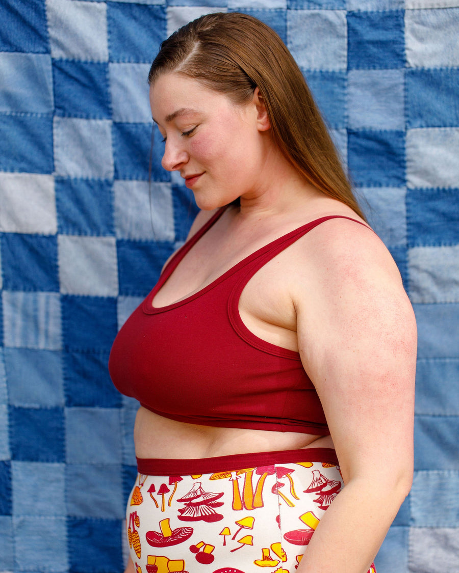 Side profile view showing the scoop neckline and side bust coverage of the Tuscan Red longline bra.