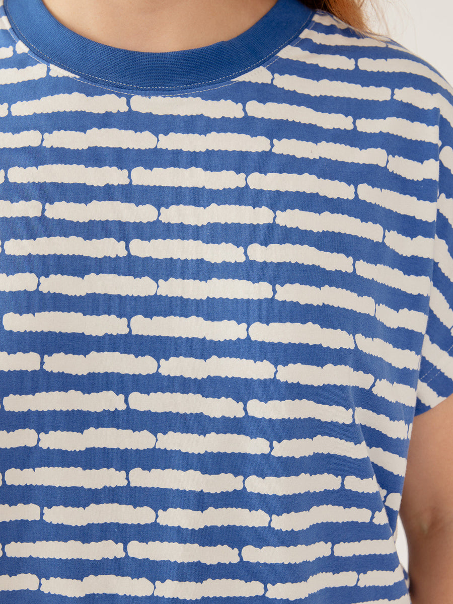 Close-up detail of the crew neckline and blue and white split stripe pattern on the organic cotton jersey fabric.